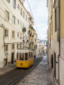 yellow and white bus in the middle of white buildings during daytime